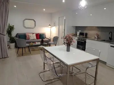 a kitchen and living room with a table and chairs at LAR JARDÍN - Casas independientes con parking privado in Santiago de Compostela