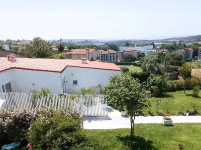 a white house with a white picket fence at LAR JARDÍN - Casas independientes con parking privado in Santiago de Compostela