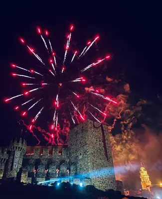 a fireworks display in the sky over a building at Castillo Buenavista in Ponferrada