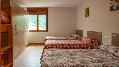 a bedroom with a bed and a cabinet and a window at Albergue Castro Domum in Castrillo de Cabrera