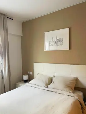 a bedroom with a white bed with a picture on the wall at Lucus Urban Centre in Lugo
