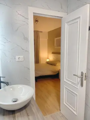 a bathroom with a sink and a room with a bed at Lucus Urban Centre in Lugo