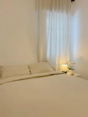 a bedroom with a white bed with a window at Lucus Urban Centre in Lugo