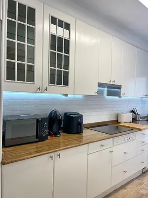 a kitchen with white cabinets and a microwave at Lucus Urban Centre in Lugo