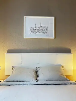 a bed with two pillows and a picture on the wall at Lucus Urban Centre in Lugo