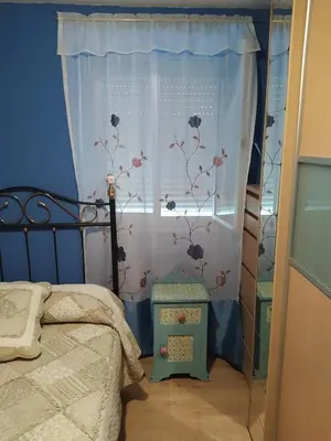 a bedroom with a bed and a window with flowers at Casa Marcelino in Reinante