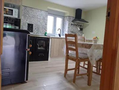 a kitchen with a table and chairs and a refrigerator at Casa Marcelino in Reinante