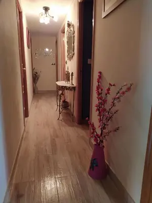 a hallway with a pink vase with flowers in it at Casa Marcelino in Reinante