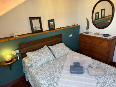 a bedroom with a bed with a mirror and towels on it at La casa Azul in Allariz