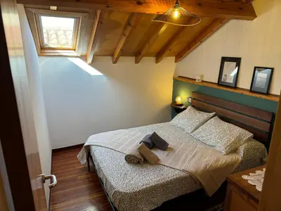 a bedroom with two beds and a window at La casa Azul in Allariz