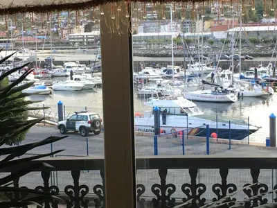 a view from a window of a marina with boats at Piso de tres habitaciones frente al Puerto Deportivo in Viveiro