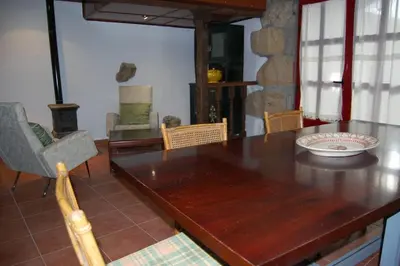 a dining room with a wooden table and chairs at A Casa do Buxo in Casardeita