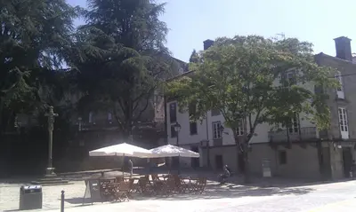 a table with an umbrella in front of a building at Apartamento Tránsito de Entrerruas in Santiago de Compostela