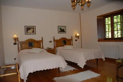 a bedroom with two beds with white blankets at El Urogallo in Noceda