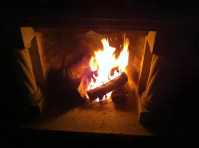 a fire in a brick oven with flames in it at El Urogallo in Noceda