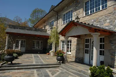 an exterior view of a stone house with a patio at El Urogallo in Noceda