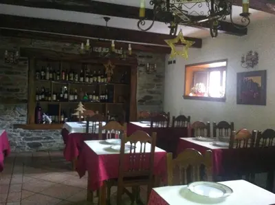a restaurant with tables and chairs with pink table cloth at El Urogallo in Noceda
