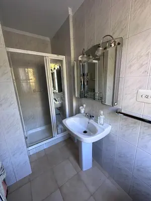 a white bathroom with a sink and a shower at Casa Lugar de Fidalgo in Vilamor