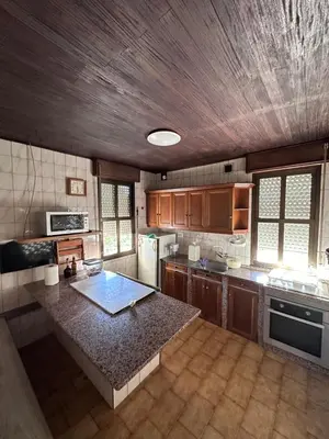 a large kitchen with a wooden ceiling at Casa Lugar de Fidalgo in Vilamor