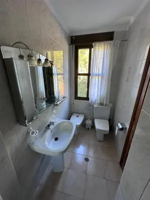 a white bathroom with a sink and a toilet at Casa Lugar de Fidalgo in Vilamor