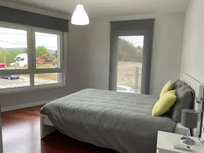 a bedroom with a bed and a large window at Casa Pilar Primero in Sigüeiro