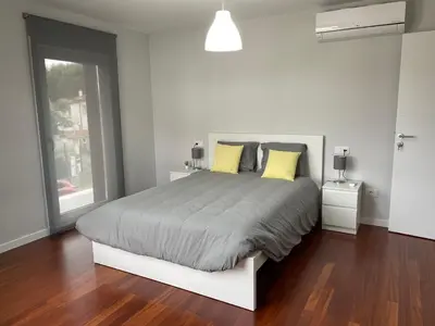 a white bedroom with a large bed with yellow pillows at Casa Pilar Primero in Sigüeiro