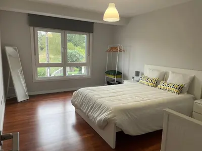 a bedroom with a large white bed and a window at Casa Pilar Primero in Sigüeiro