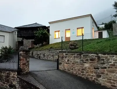 a house with a stone wall and a gate at Mini Room Ron in Merou