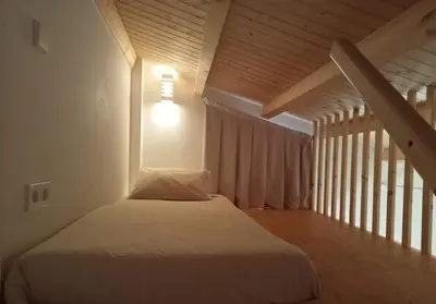 a bedroom with a bed with a light on the wall at Mini Room Ron in Merou