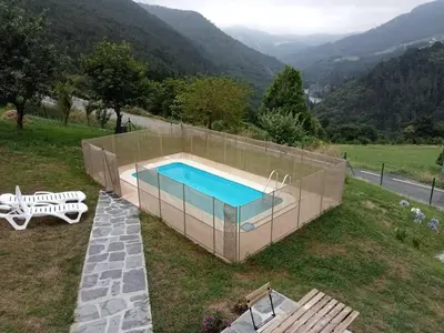 a swimming pool on top of a field with a mountain at Mini Room Ron in Merou
