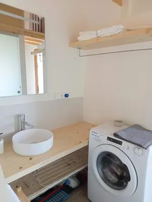 a washing machine in a bathroom with a sink at Mini Room Ron in Merou