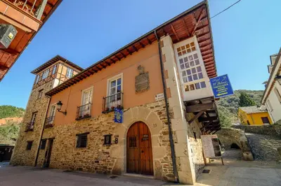 an old stone building with a wooden door at Hostal El Palacio in Molinaseca