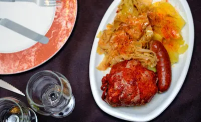 a plate of food with sausage and pasta on a table at Hostal El Palacio in Molinaseca