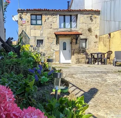 a stone house with a garden in front of it at A Calma in Paradela