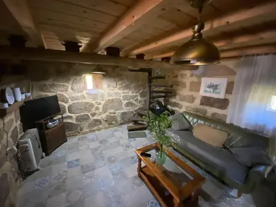 a living room with a green couch and a tv at A Calma in Paradela