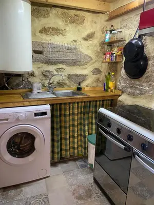 a kitchen with a washing machine and a sink at A Calma in Paradela