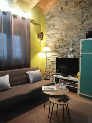 a living room with a couch and a tv at Refugio Alto Sil in Páramo del Sil