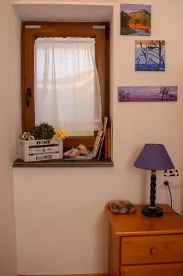 a room with a window and a table with a lamp at Refugio Alto Sil in Páramo del Sil