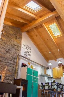 a kitchen with wooden ceilings and a green refrigerator at Refugio Alto Sil in Páramo del Sil