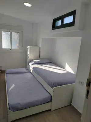two beds in a small room with a window at Casa de Josiño in Villamateo