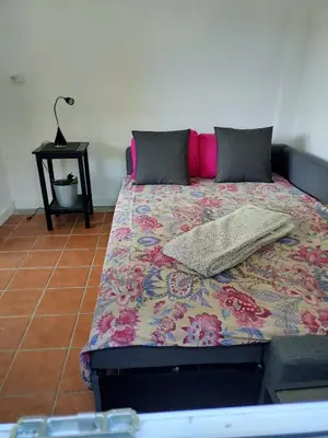 a bedroom with a bed with a floral bedspread at Casa de Josiño in Villamateo