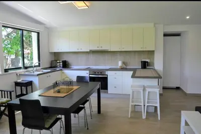 a kitchen with white cabinets and a table and chairs at Casa de Josiño in Villamateo