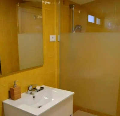 a bathroom with a sink and a shower with a mirror at Casa de Josiño in Villamateo