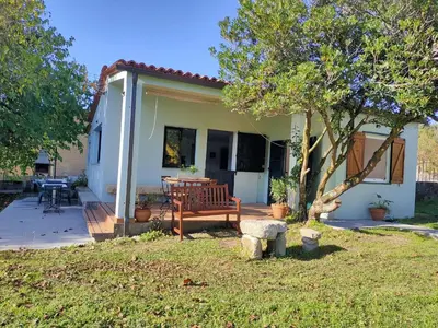 a house with a wooden bench and a tree at Casa de Josiño in Villamateo