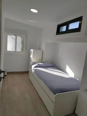 a bedroom with a bed and two windows at Casa de Josiño in Villamateo