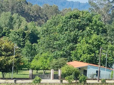 a house with a fence in front of some trees at Casa de Josiño in Villamateo