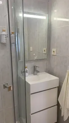 a bathroom with a sink and a shower with a mirror at O Pisiño in Ourense