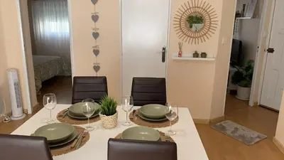 a dining room with a table with green plates and wine glasses at O Pisiño in Ourense