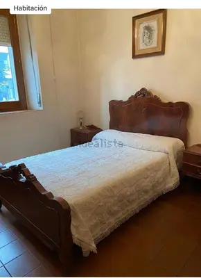 a bedroom with a large bed with a wooden headboard at Don Xesús in Ourense