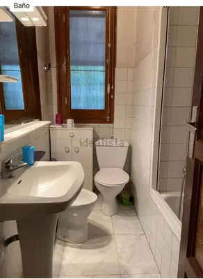 a white bathroom with a toilet and a sink at Don Xesús in Ourense